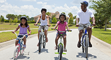 Family riding bikes with helmets on