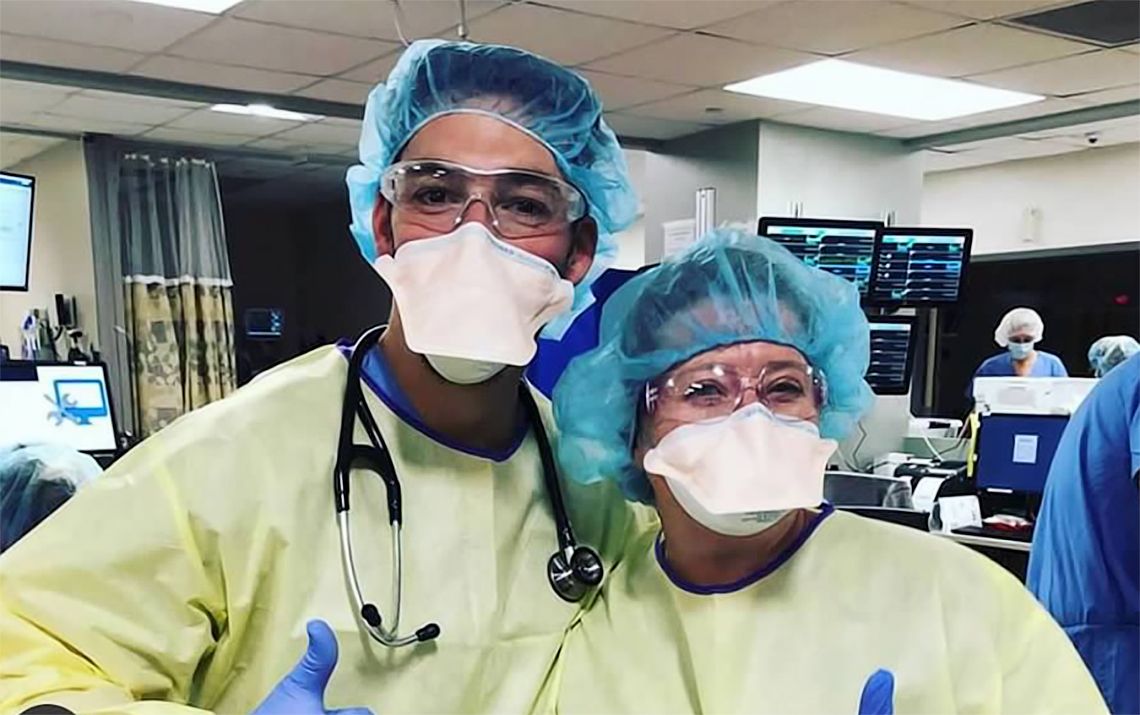 Two medical professionals in their natural habitat, wearing gloves and masks