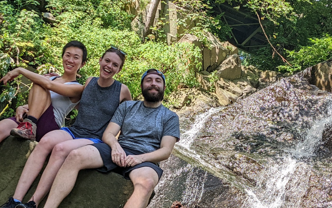 Residents posing next to a waterfall after a nearby hike
